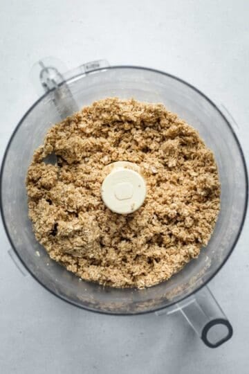 Showing the texture of the oat mixture in the food processor before pressing into a pie plate.