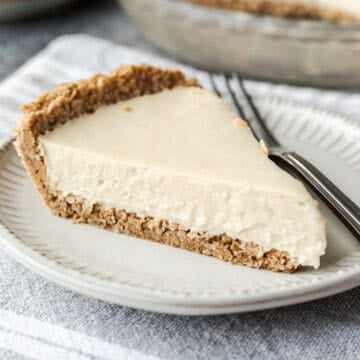 Side view of a slice of pie on a plate showing the texture of the pulsed oat crust.