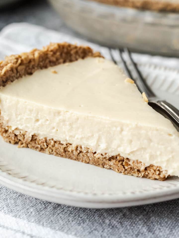 Side view of a slice of pie on a plate showing the texture of the pulsed oat crust.