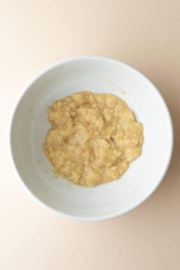 Mashed bananas in a large mixing bowl.