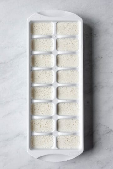 An oat-cashew mixture poured into an ice cube tray, ready to go in the freezer.