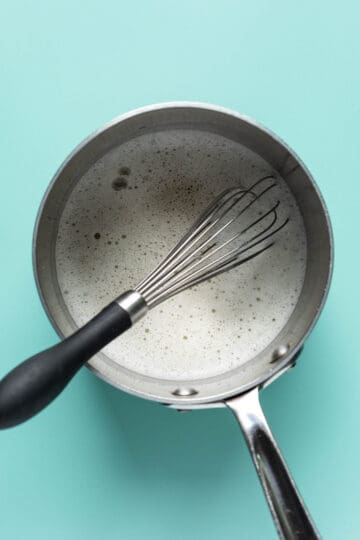 Heating aquafaba and sugar in a small saucepan.