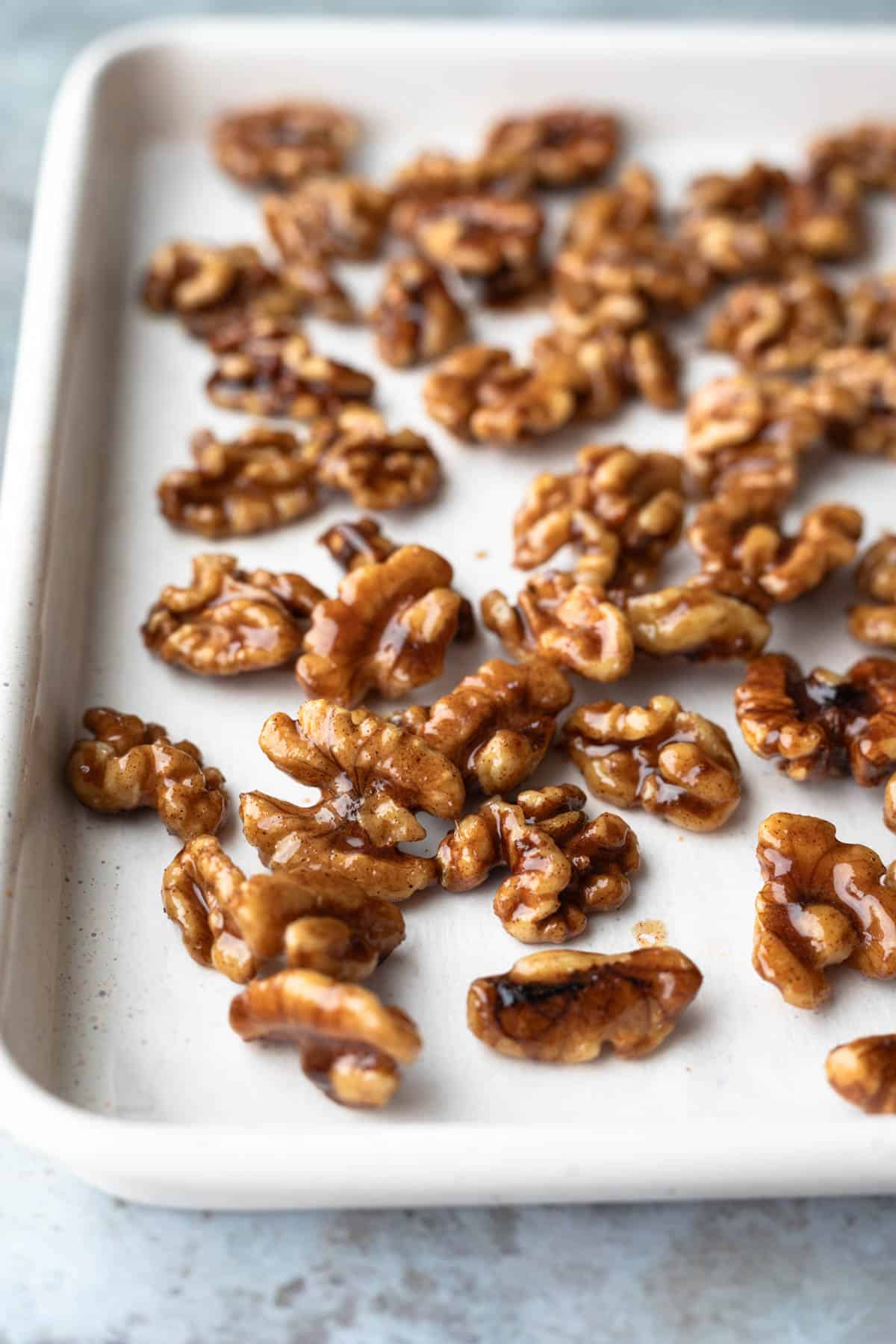Maple candied walnuts cooling on a sheet pan.