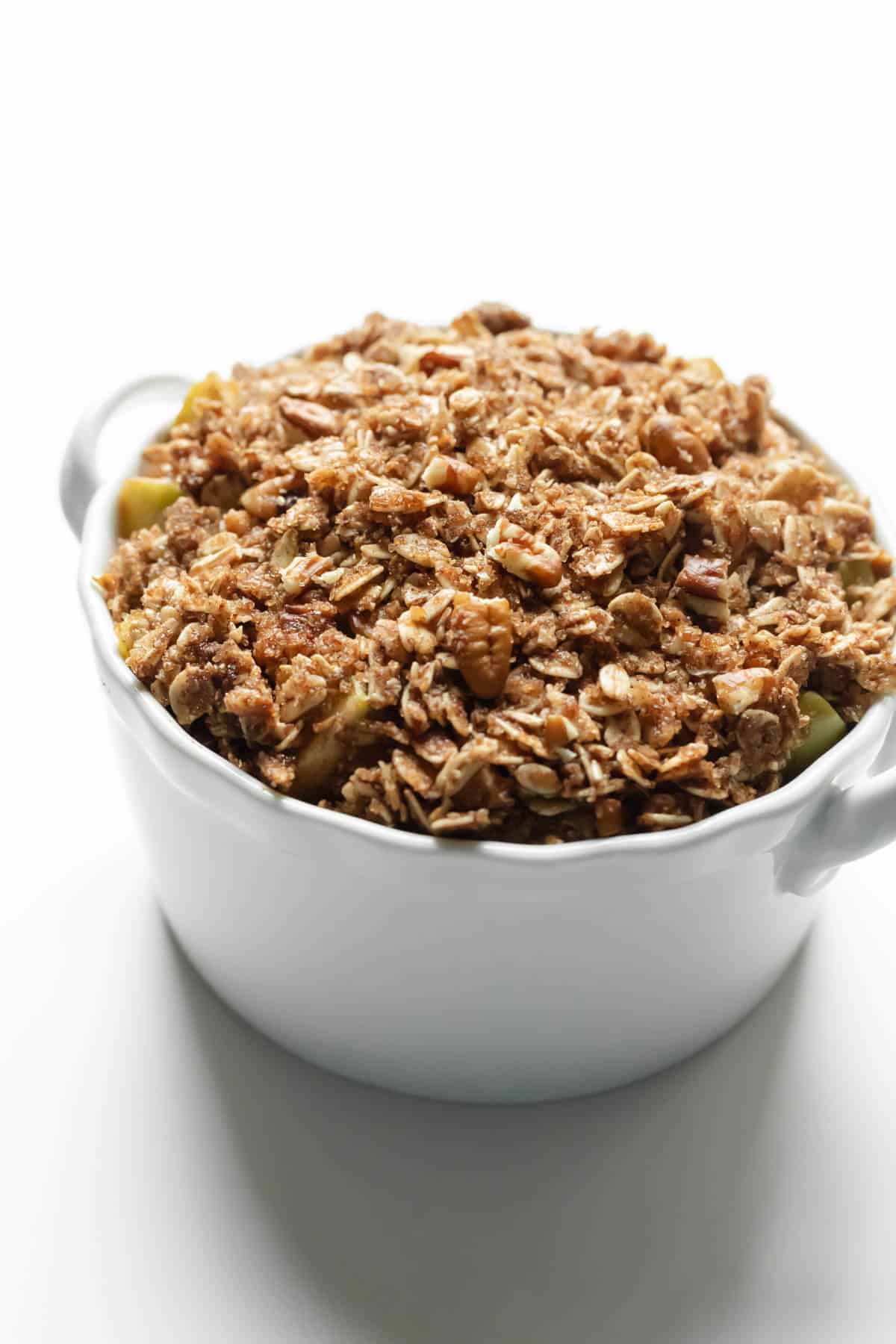 A 3-serving apple crisp topped with oat crumble topping, ready to be cooked in the microwave.