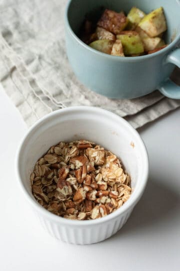 Combining oats, pecans, oil, and spices in a small bowl for the topping.