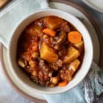 Overhead view of a bowl full of potato stew made with chickpeas, carrot and tomatoes.