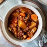 Overhead view of a bowl full of potato stew made with chickpeas, carrot and tomatoes.