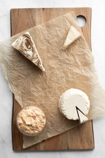 First, arrange the cheeses on the board or platter.