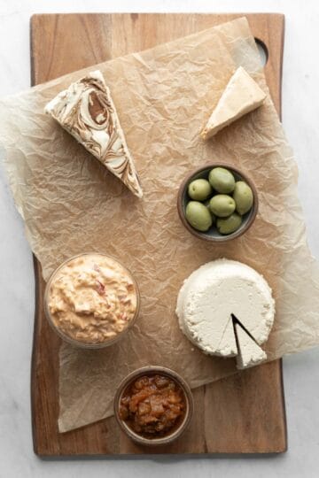 Dips and foods in small bowls are the next items to add to the cheese board.