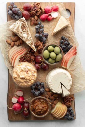 The final stage of building a cheese board, adding the nuts and crackers.