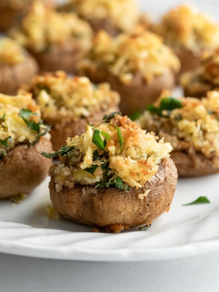 Stuffed mushrooms arranged on a white serving plate.