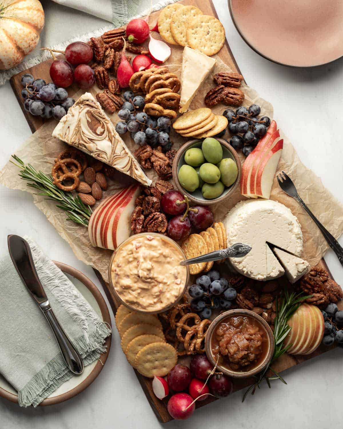 A Fall-inspired vegan cheese board with an assortment of dairy-free cheese, crackers, and snacks.
