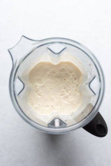 Looking inside a blender at the creamy blended tofu filling.