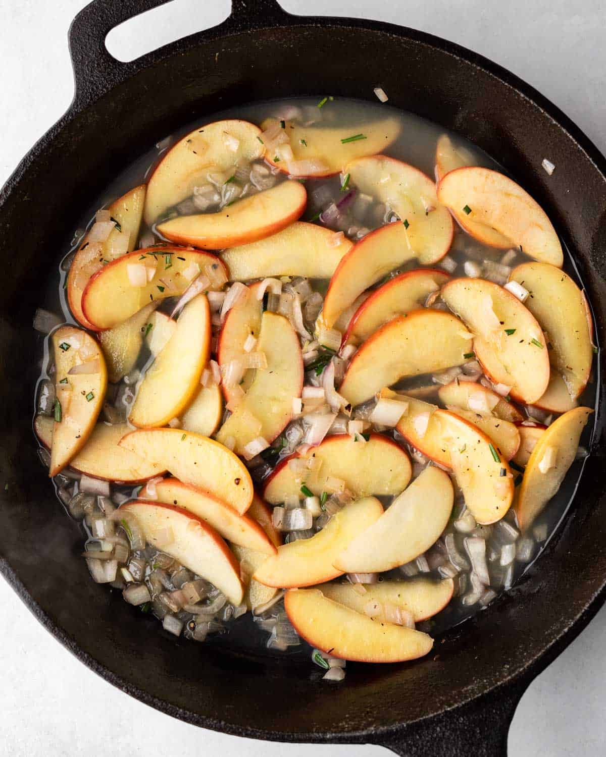 Deglazing the skillet with apple cider.