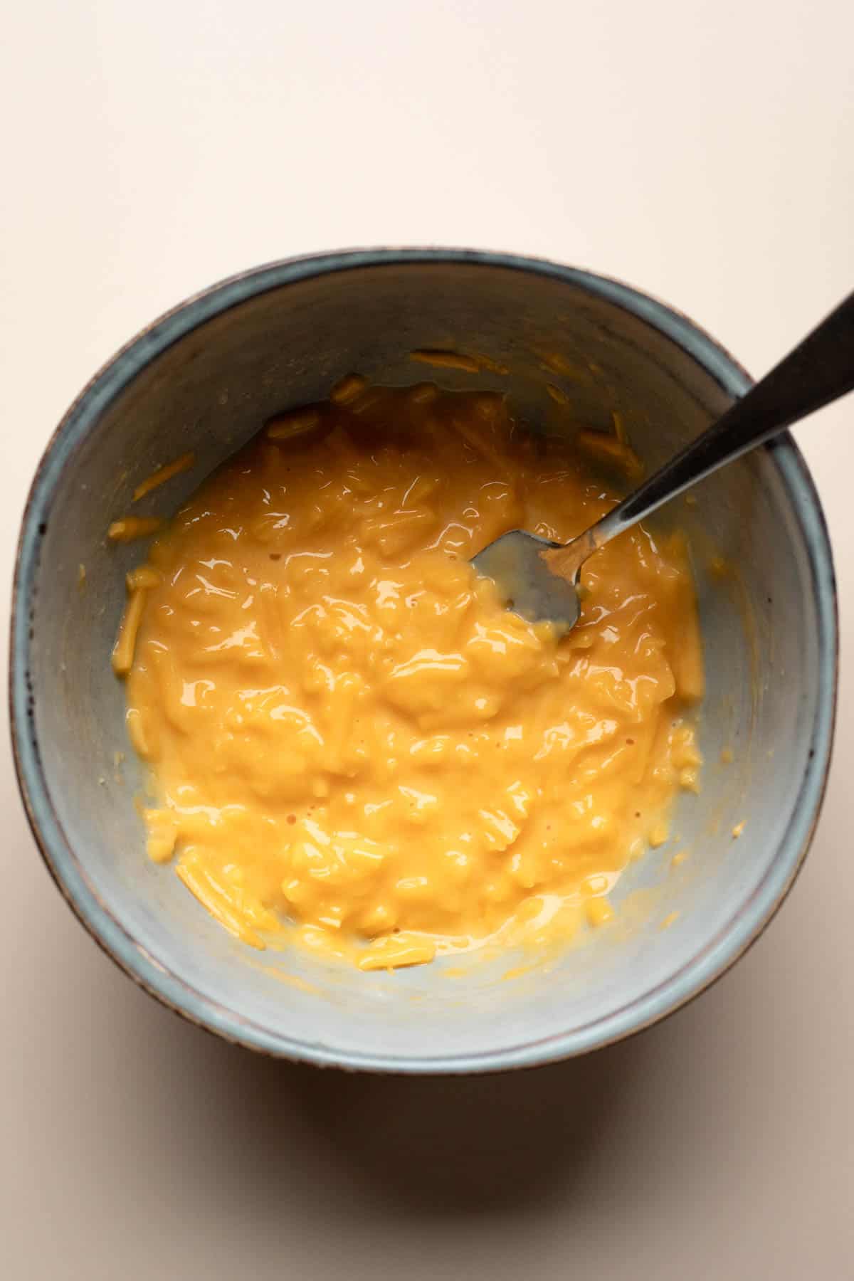 Melting shredded cheese in a bowl.