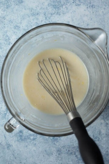 Whisking together the wet ingredients in a mixing bowl.