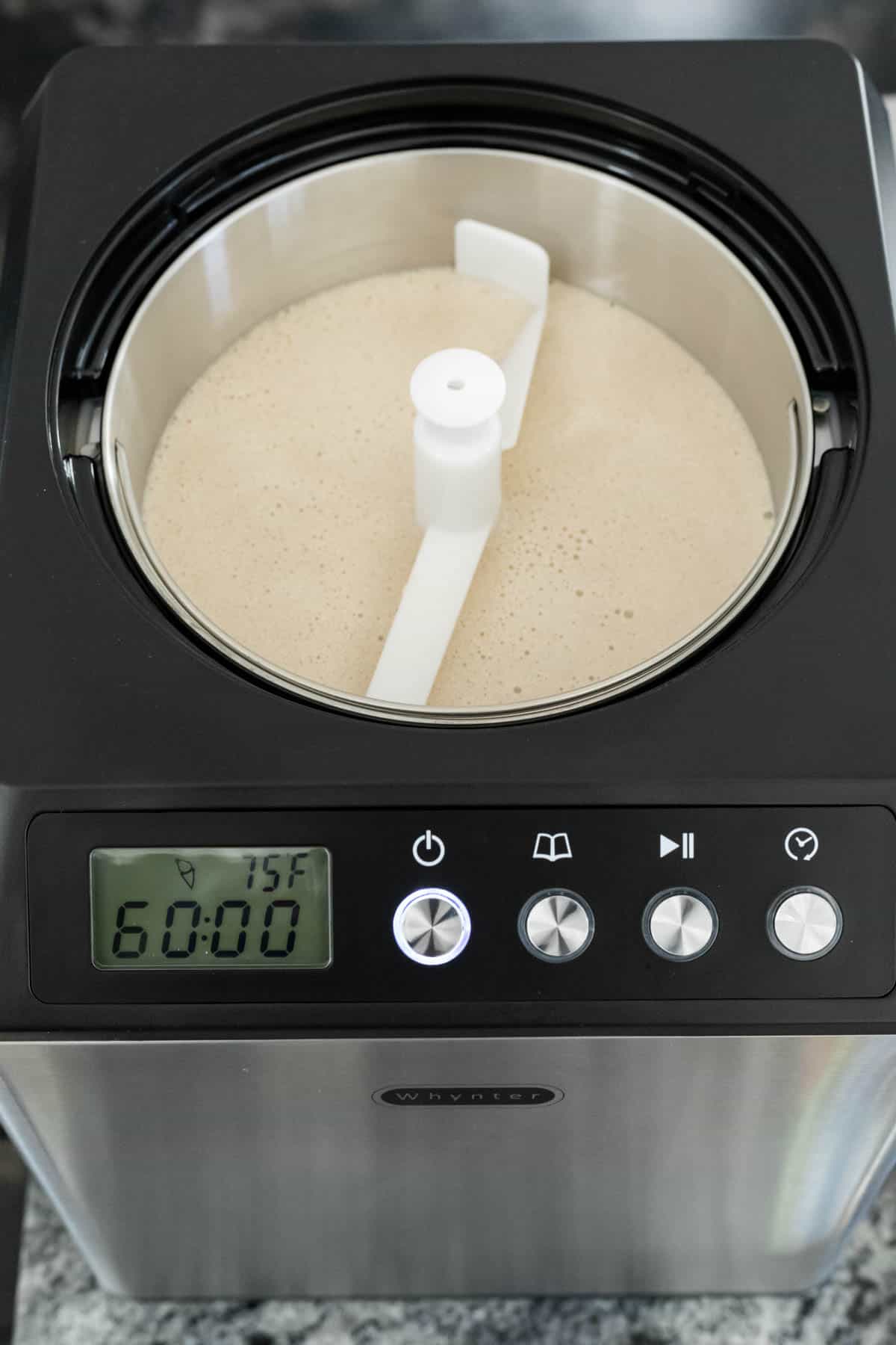 Vegan ice cream mixture poured into the bowl of an ice cream maker.