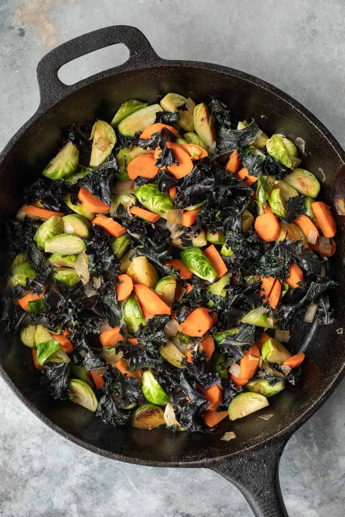 cooked veggies for winter panzanella in a cast iron pan.