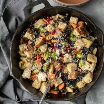 close-up overhead of winter panzanella salad in a cast iron pan.