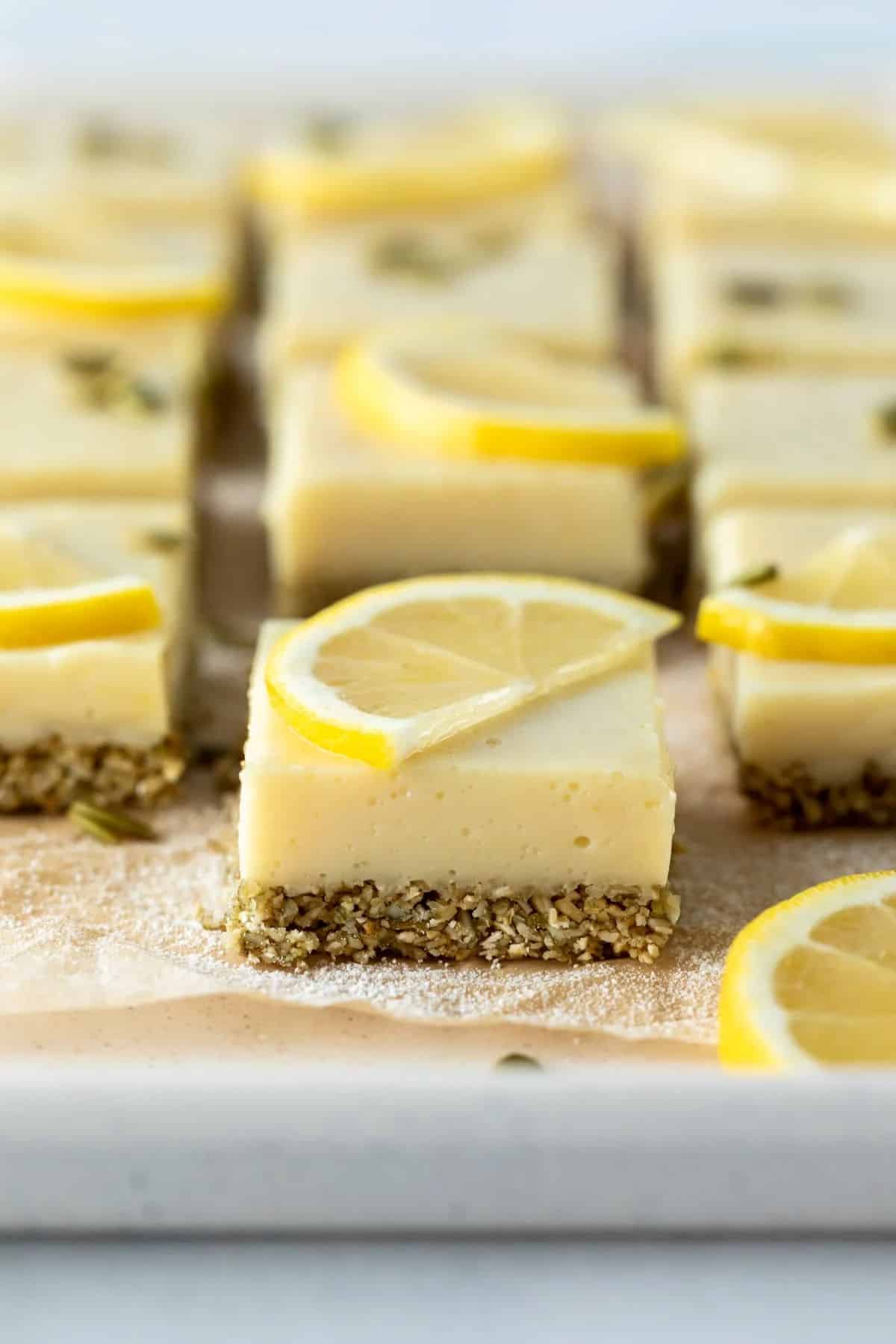 vegan lemon bars on a parchment-lined baking sheet.