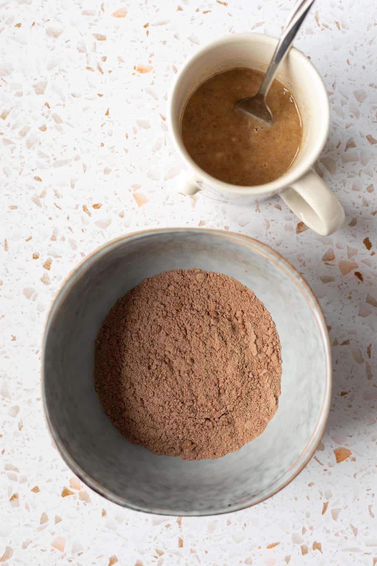 Dry ingredients in a bowl and wet ingredients in a mug.