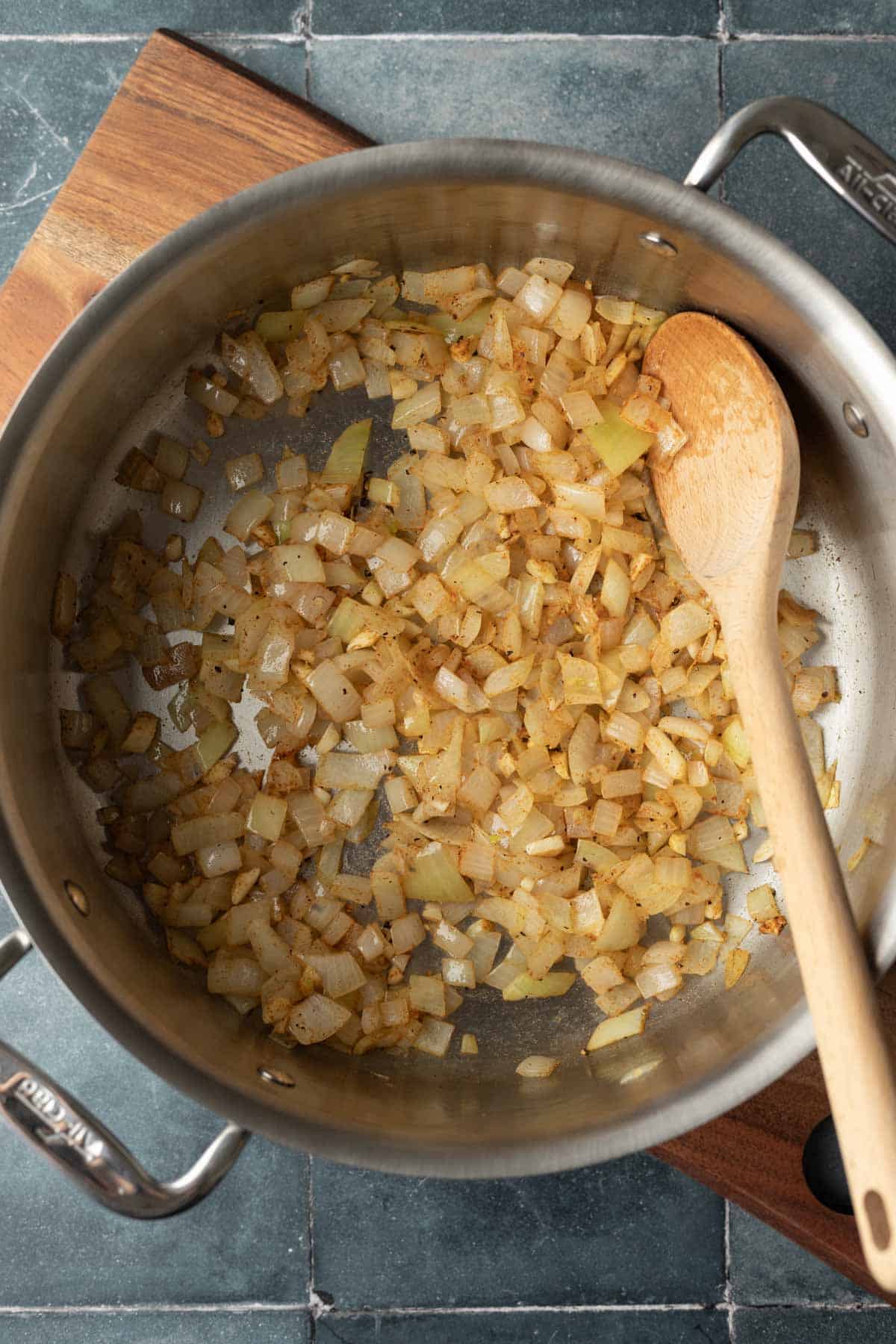 Sauteing onion with spices in a large soup pot.