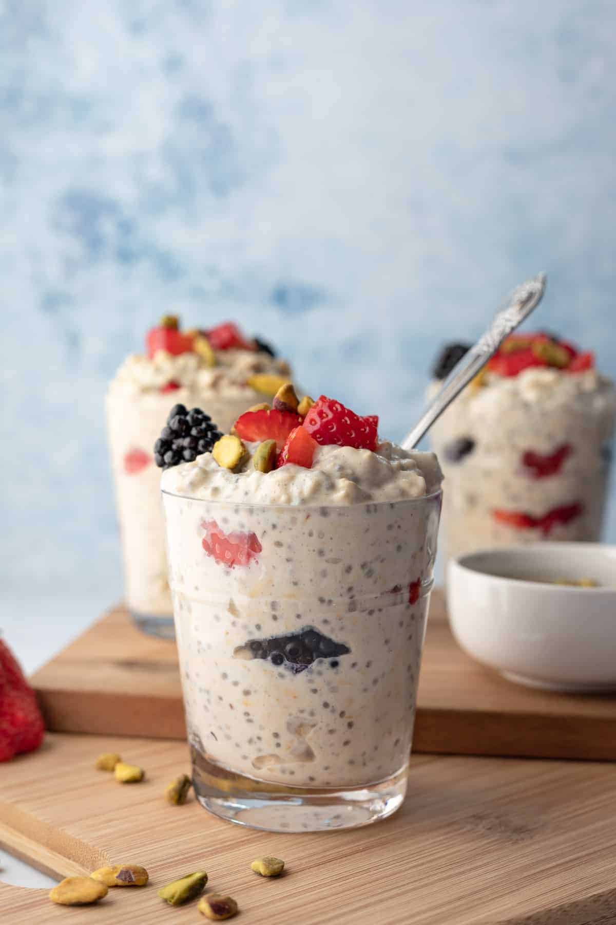 3 glasses of protein overnight oats with berries.