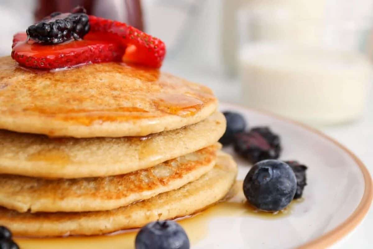 stack of pancakes on a plate with berries.