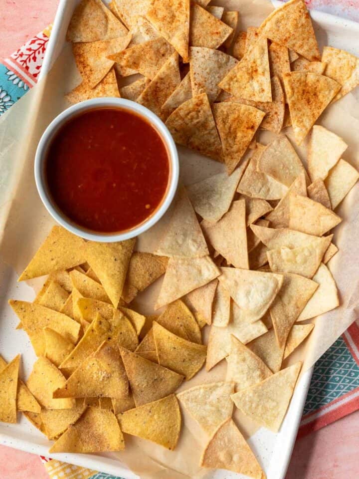 overhead of air fryer tortilla chips on a baking tray with salsa.