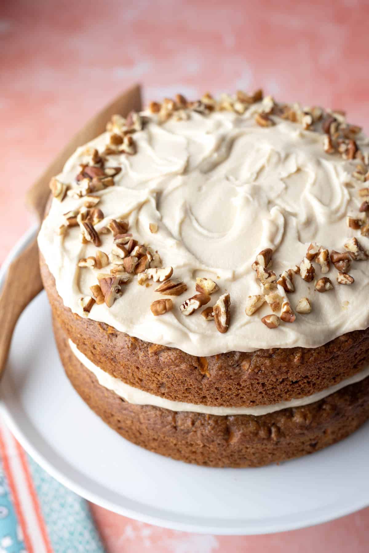 Almond flour frosting spread on top of a vegan carrot cake.