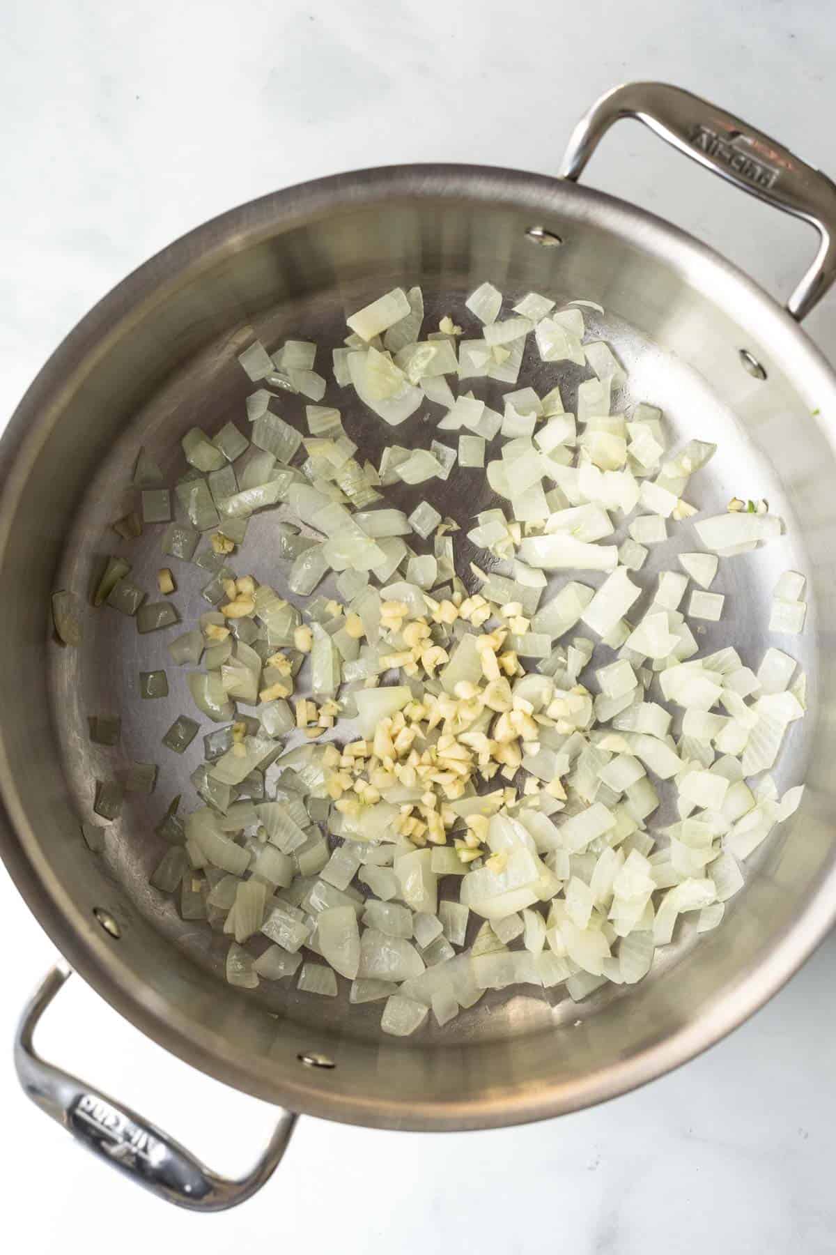 Sautéing onion and garlic in a large soup pot.