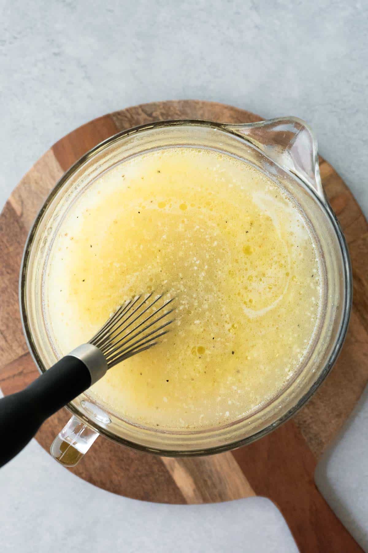Whisking polenta into hot water before pouring into the slow cooker.