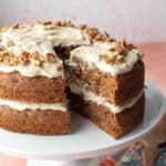 A vegan carrot cake with two layers with homemade frosting in between and on top.