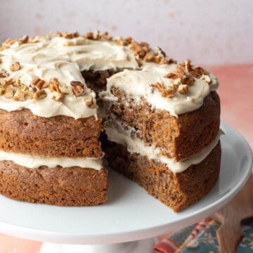A vegan carrot cake with two layers with homemade frosting in between and on top.