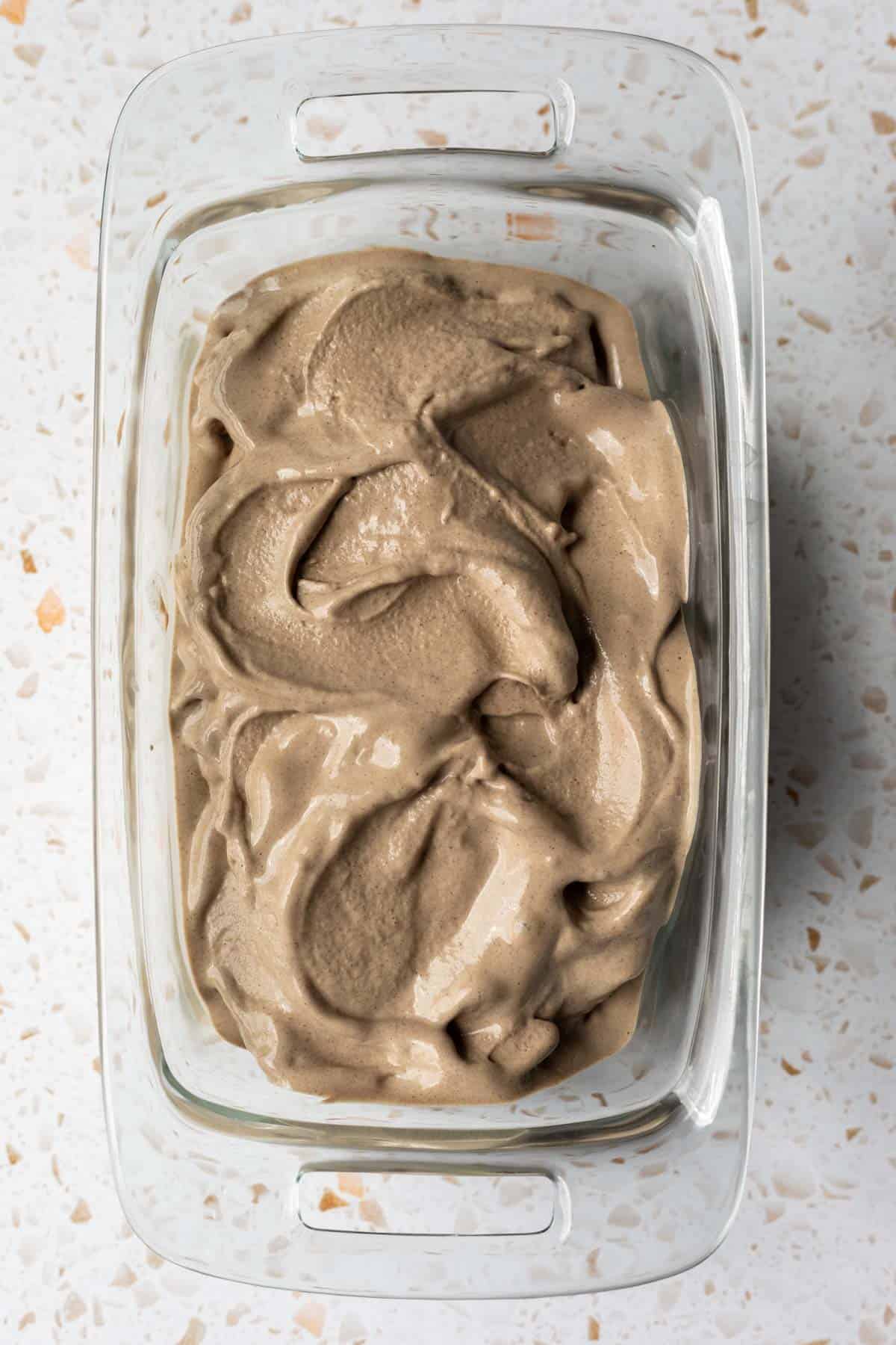 Soft serve date ice cream spread in a container ready to go in the freezer.