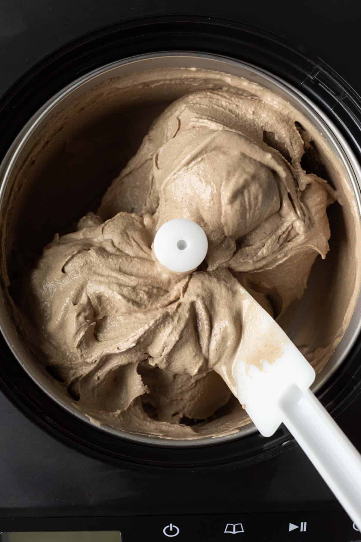 Looking inside ice cream maker at freshly churned vegan ice cream.