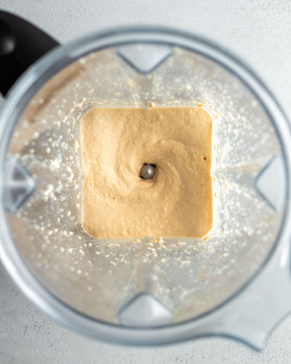 Looking inside a blender at the cashew cheese mixture.