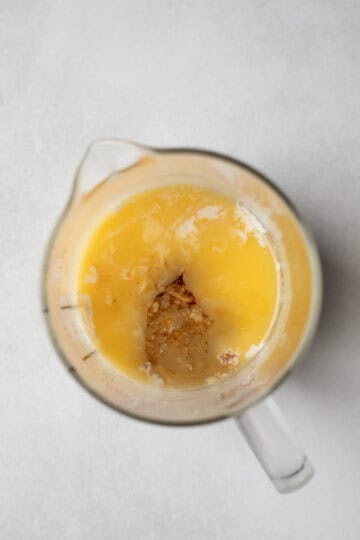 Wet ingredients mixed together in a glass measuring cup.