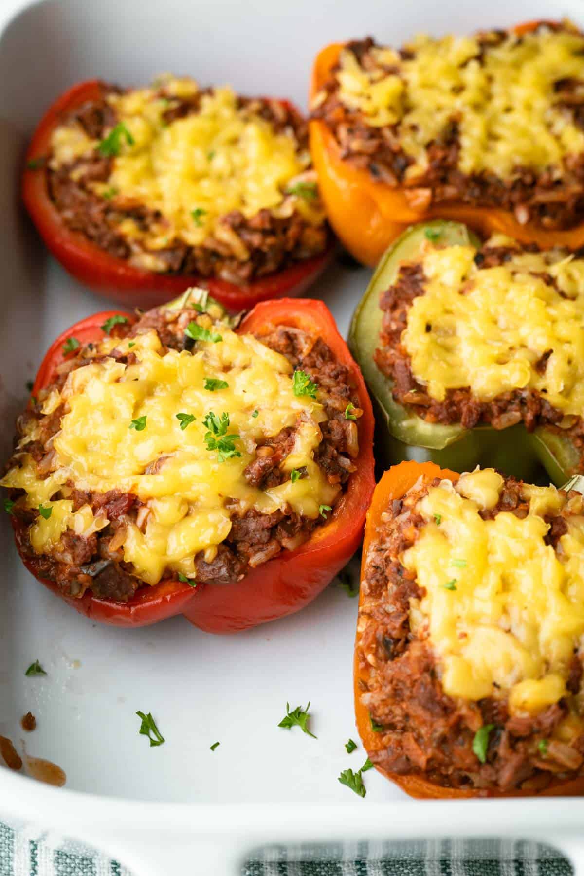 Baked stuffed peppers topped with melted vegan cheese.