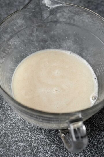 Oats, enzymes, and hot water soaking in a large mixing bowl.