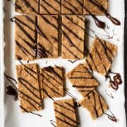 overhead of vegan protein bars on a baking sheet after being drizzled with chocolate.