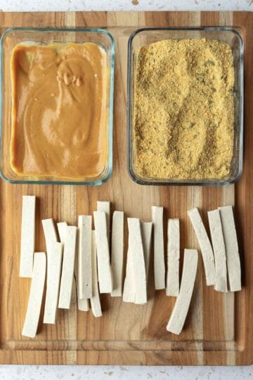 tofu breading station set up on a wooden board.