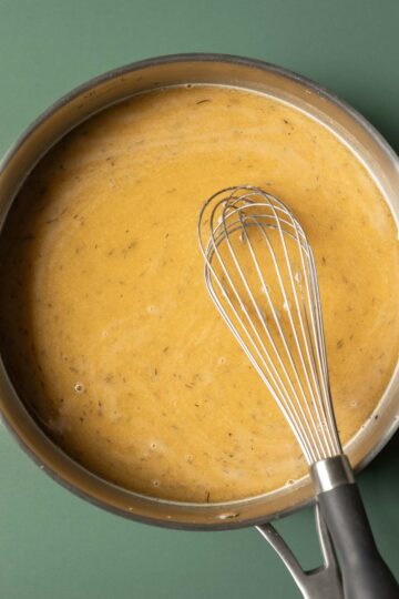 Vegetable broth has been added to the pan and will be simmered for 2-3 minutes until reduced and creamy.