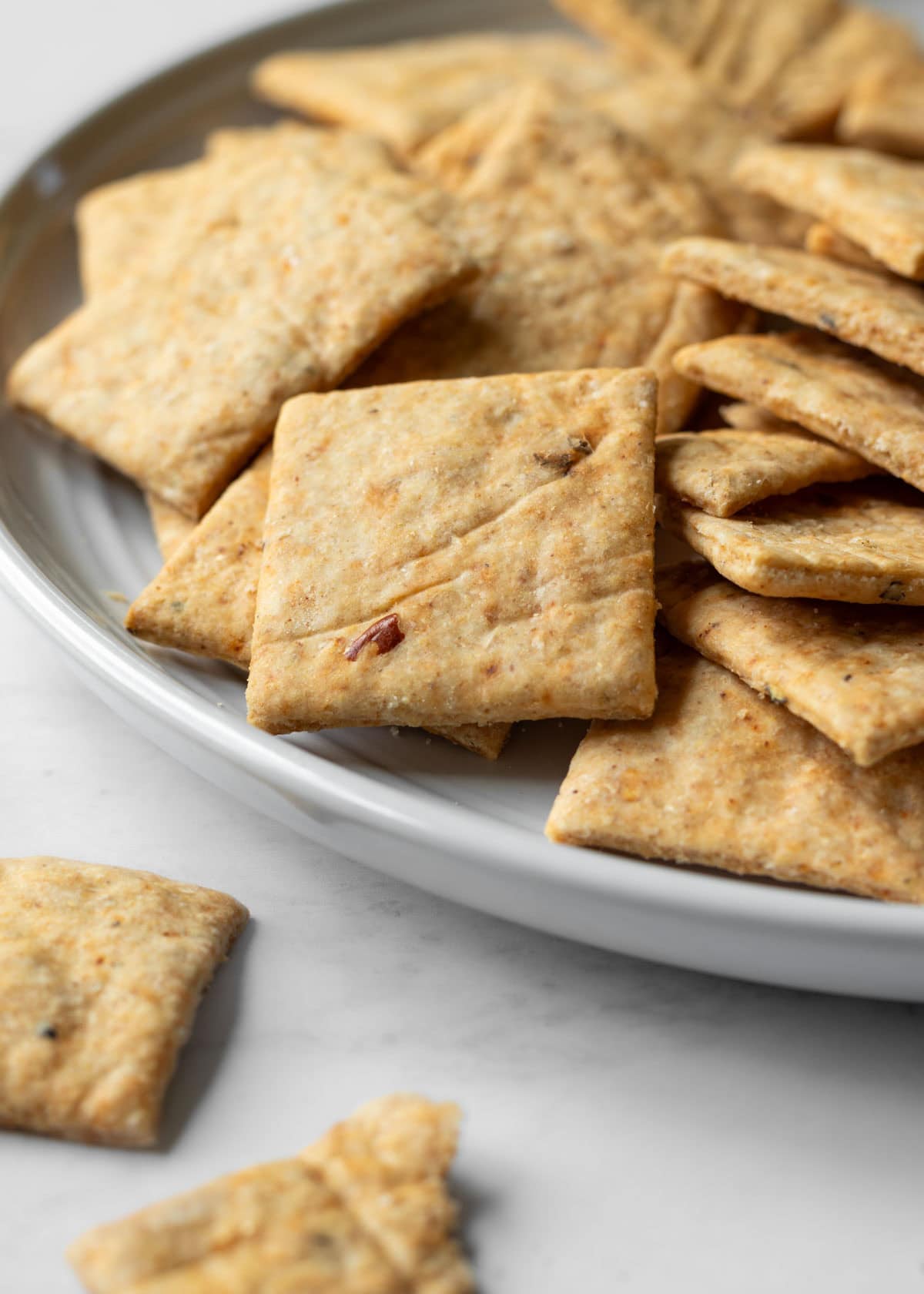 Harissa flavored homemade wheat crackers on a small plate.