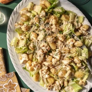 Overhead view of roasted gnocchi salad topped with creamy dressing.