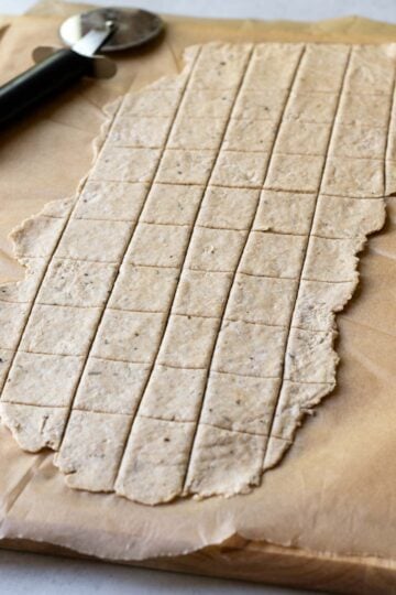 Showing how to use a pizza cutter to cut the cracker dough.