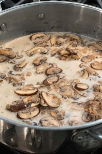 Adding non-dairy milk and flour to the saute pan.