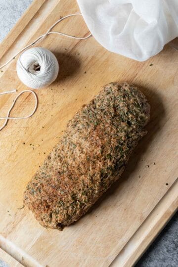 Forming the seitan into a long roast and rubbing the outside with herbs and seasonings.