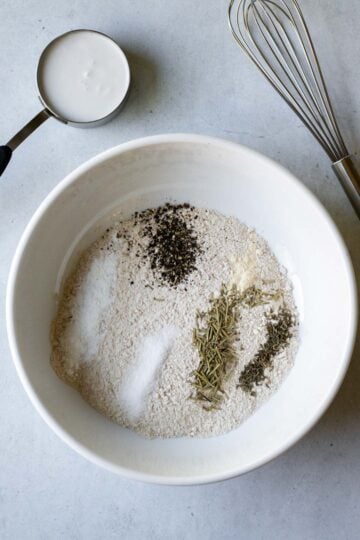 Showing how to make cracker dough with dry ingredients in a large bowl.