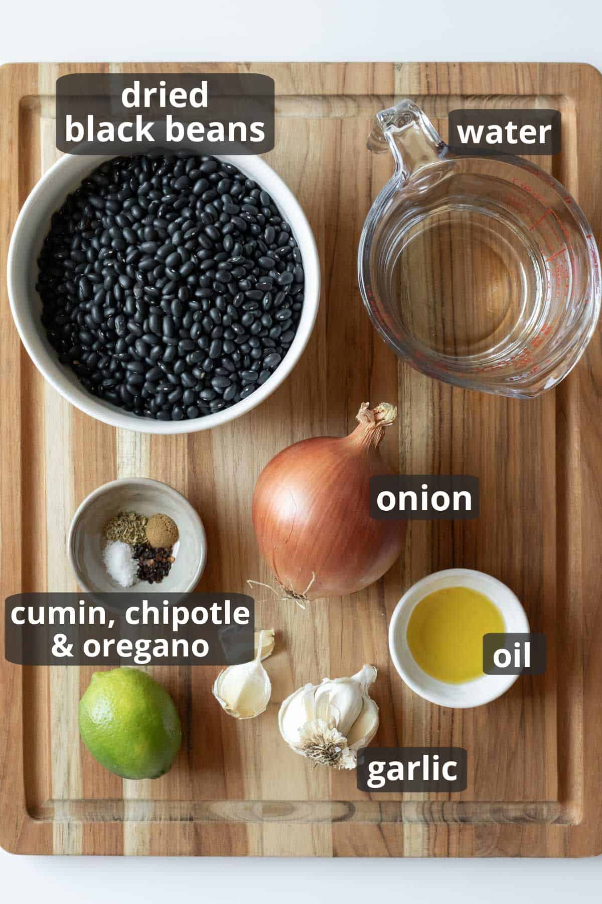 Ingredients for refried black beans on a wood surface.